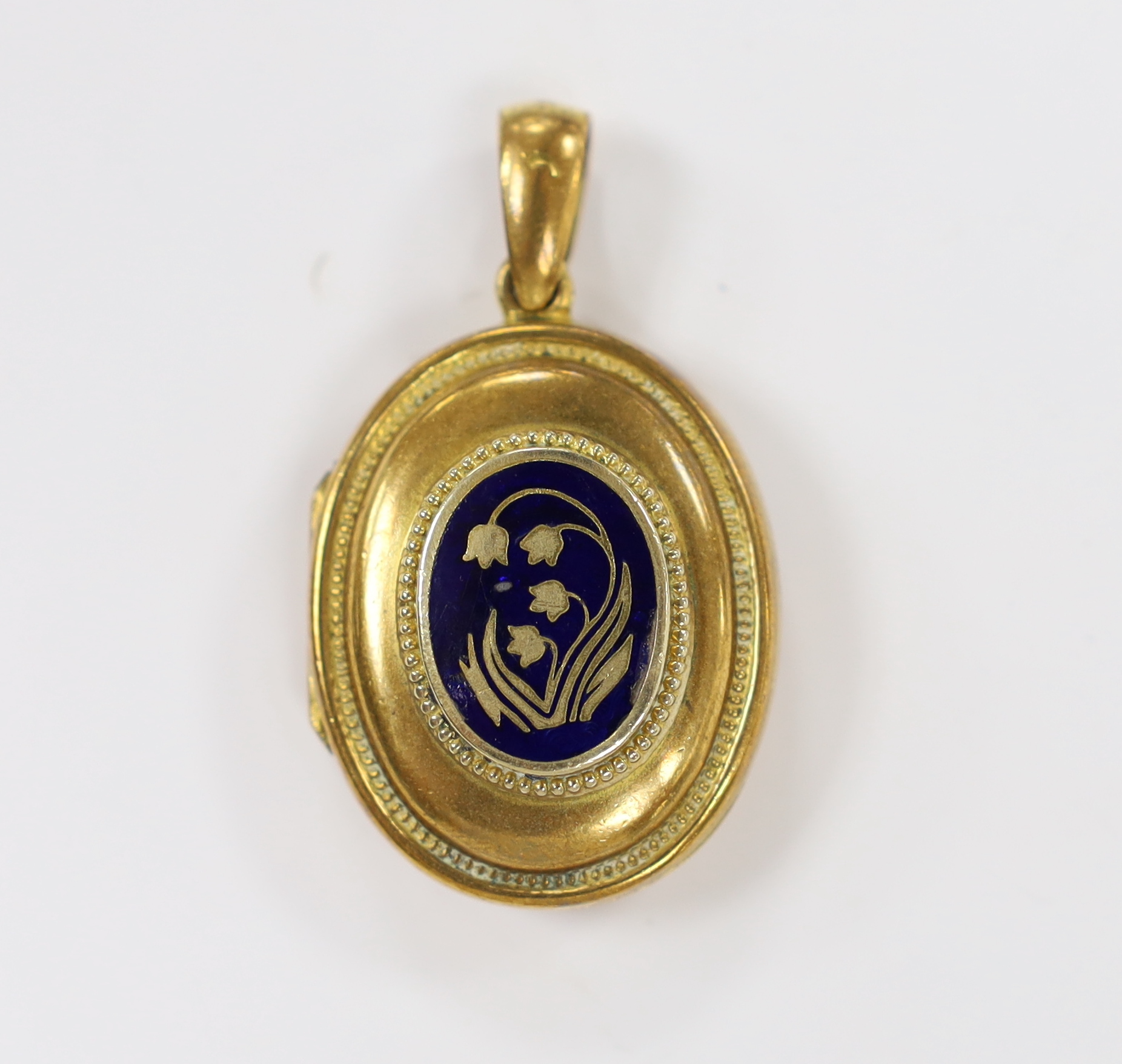 An early 20th century gilt metal and blue enamel set oval locket, with floral motif, overall 48mm, gross weight 17.3 grams.